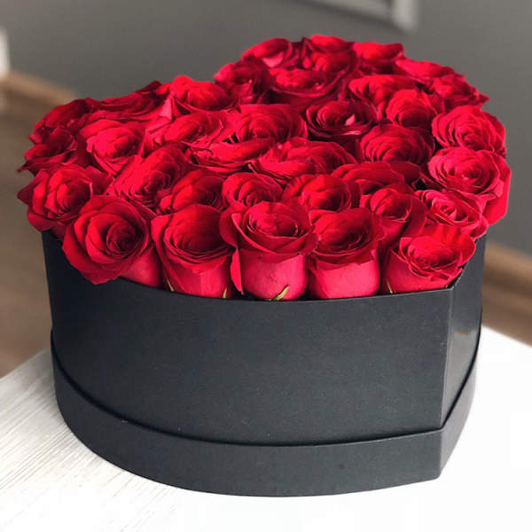 Round box of red roses in a black container