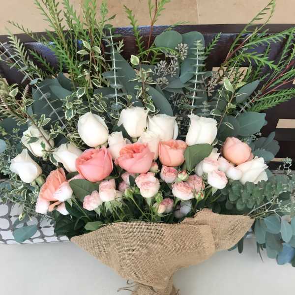 Bouquet of pink and white roses wrapped in burlap