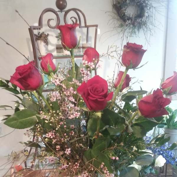 Tall bouquet of red roses in a clear glass vase