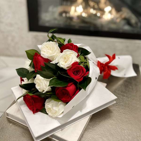Bouquet of red and white roses wrapped in white paper