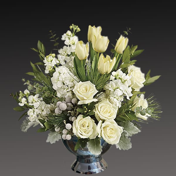 White roses and tulips arranged in a glass vase