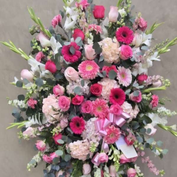 Large pink and white floral standing spray on an easel