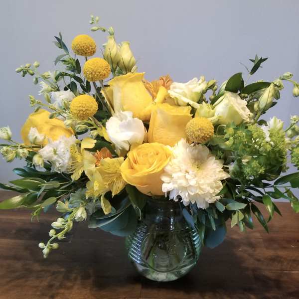 Yellow and white floral arrangement in a glass vase