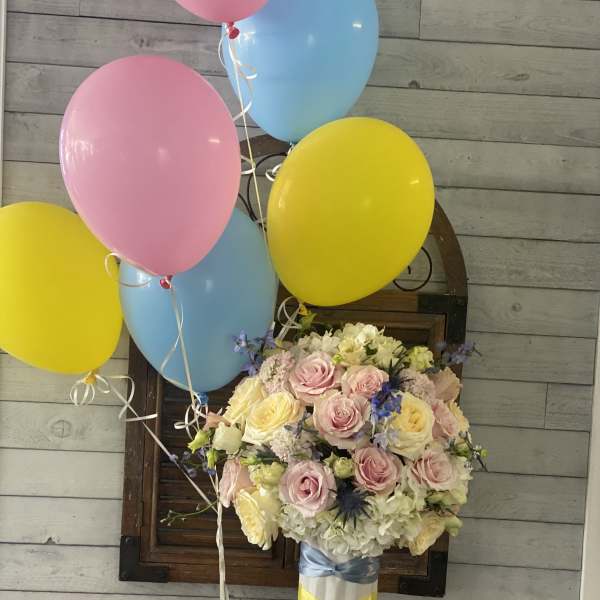 Pastel rose bouquet with pink, yellow, and blue balloons
