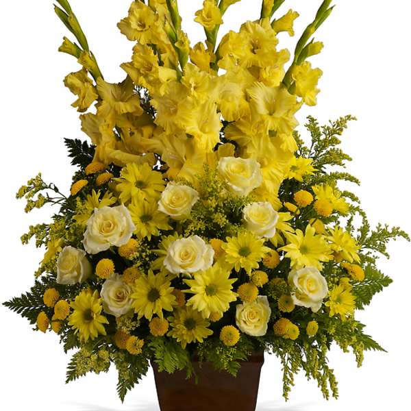 Yellow floral arrangement in a brown urn vase