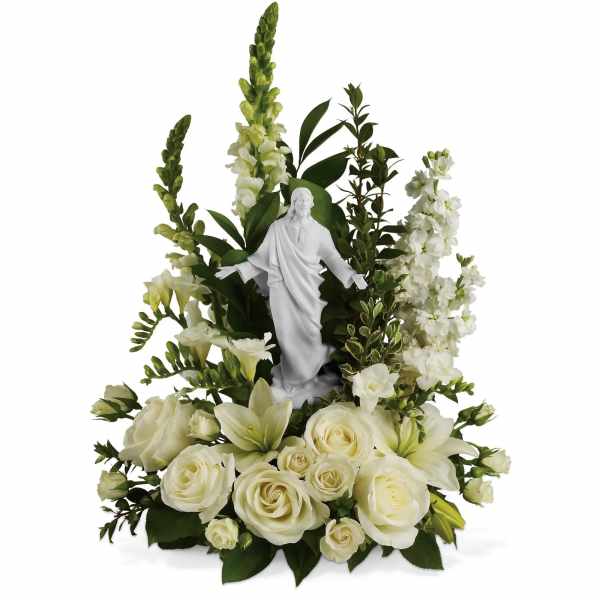 White floral arrangement with a small religious statue in the center