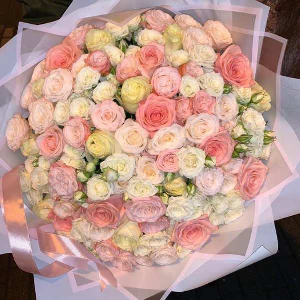 Large bouquet of pastel roses wrapped in pink paper