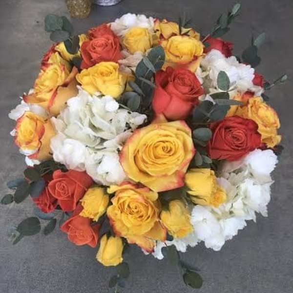 Round bouquet of red, yellow, and white roses with eucalyptus