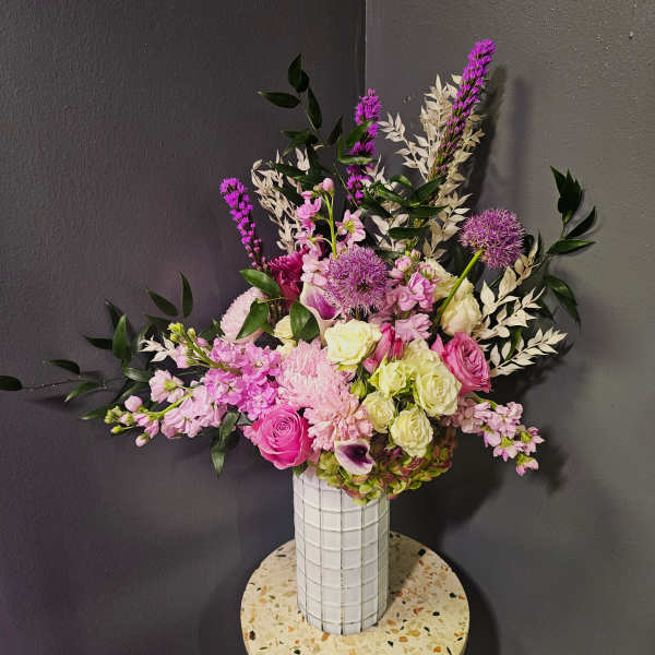 Pink and white mixed bouquet in a tall white vase