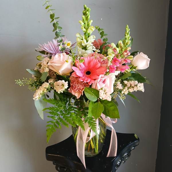 Mixed pink and white bouquet in a glass vase with ribbon
