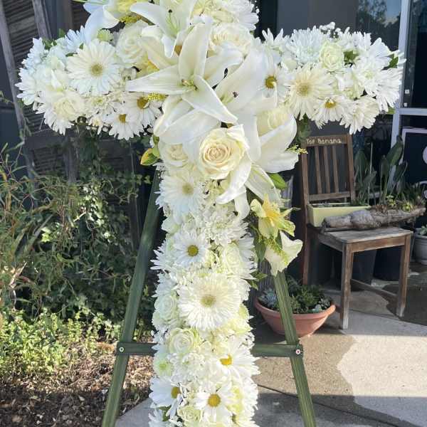 White floral standing cross on an easel
