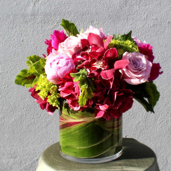 Pink and red floral arrangement in a glass vase