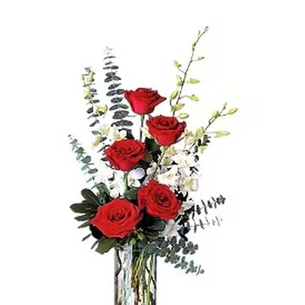 Red roses arranged in a clear glass vase with airy filler flowers
