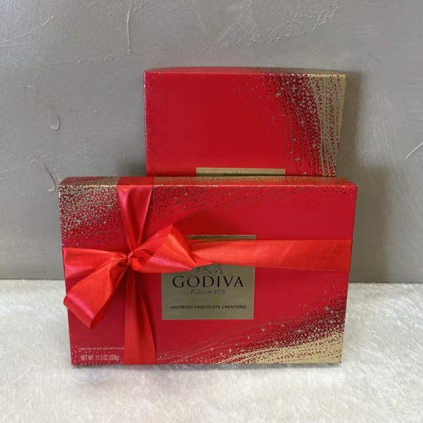 Two red Godiva chocolate gift boxes with a satin ribbon