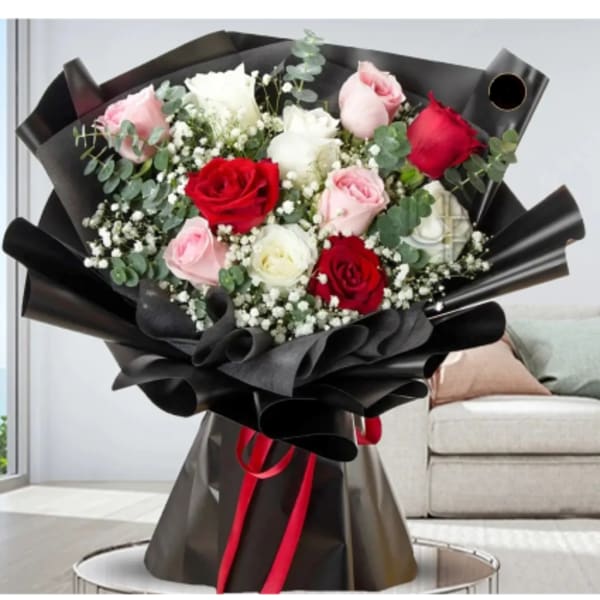 Bouquet of red, pink, and white roses wrapped in black paper
