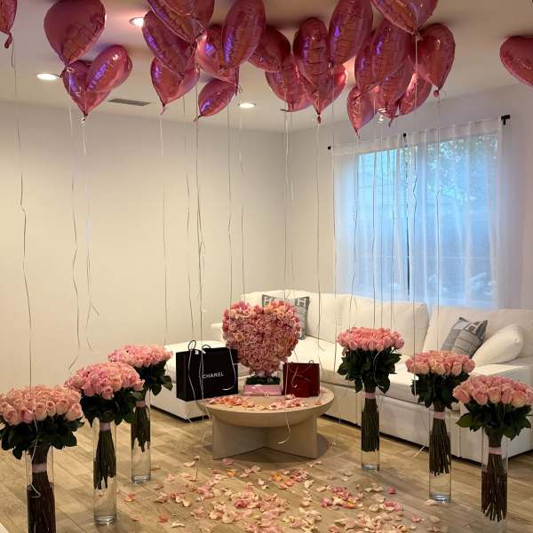 Pink rose arrangements with heart balloons in a living room
