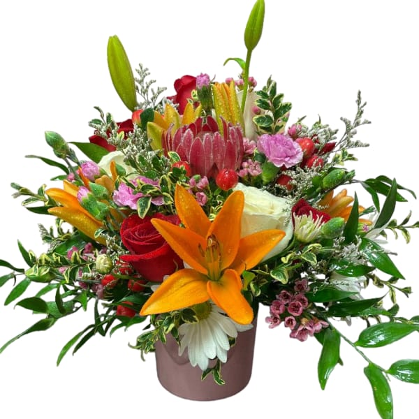 Mixed bouquet with lilies, roses, and pink accents in a vase