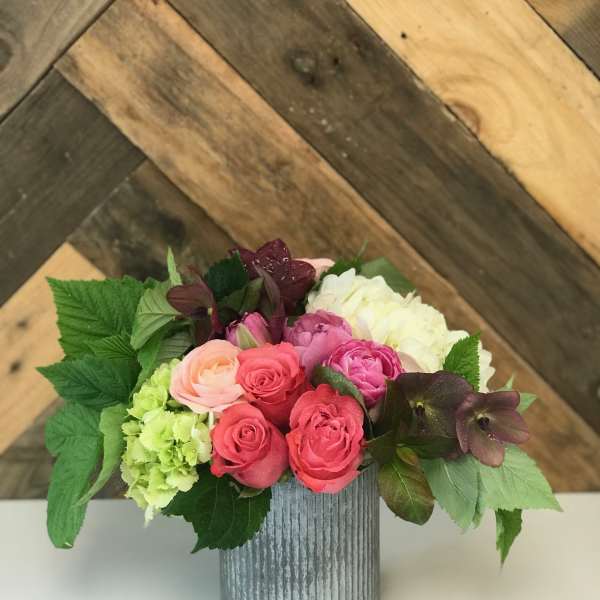 Mixed pink and white flowers arranged in a ribbed metal vase