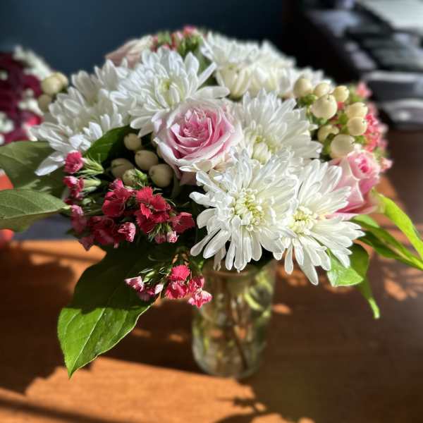 Pink rose and white daisy bouquet in a glass vase