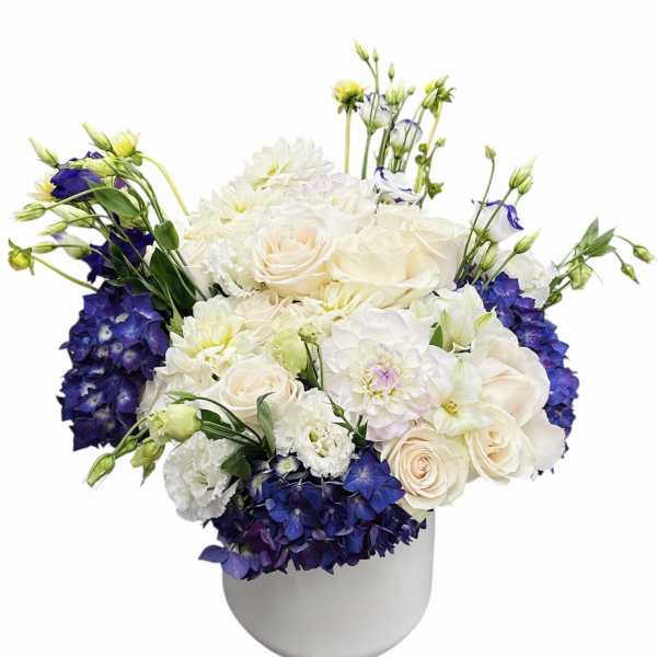 White and blue floral arrangement in a white vase