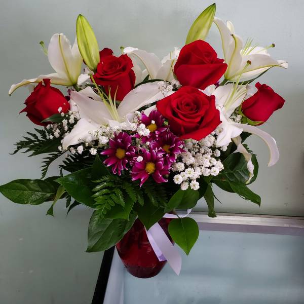 Bouquet of red roses and white lilies in a red vase