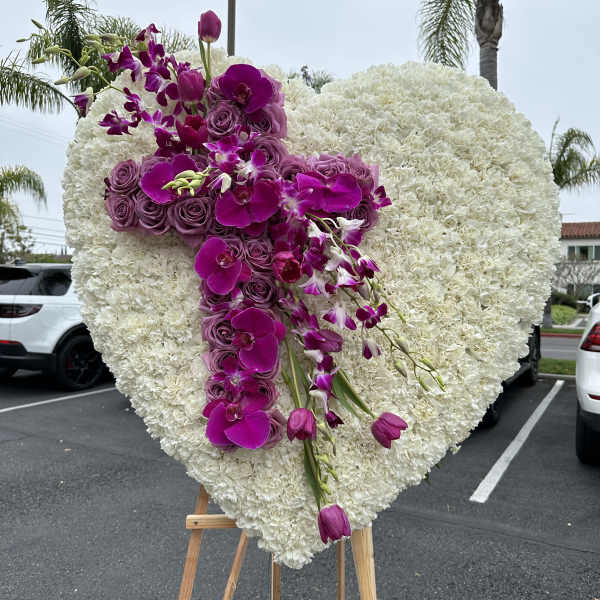 Heart-shaped white floral spray with purple orchids and roses