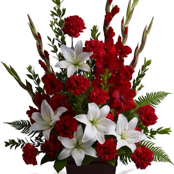 Red and white floral arrangement in a dark vase