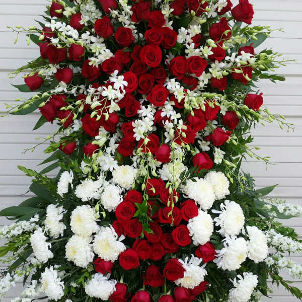 Large standing spray of red roses and white flowers on an easel