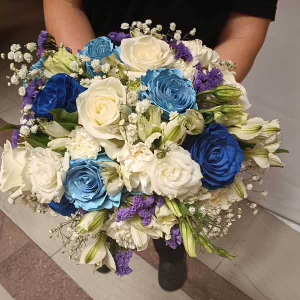 Large bouquet of blue, white, and purple roses with small white filler flowers