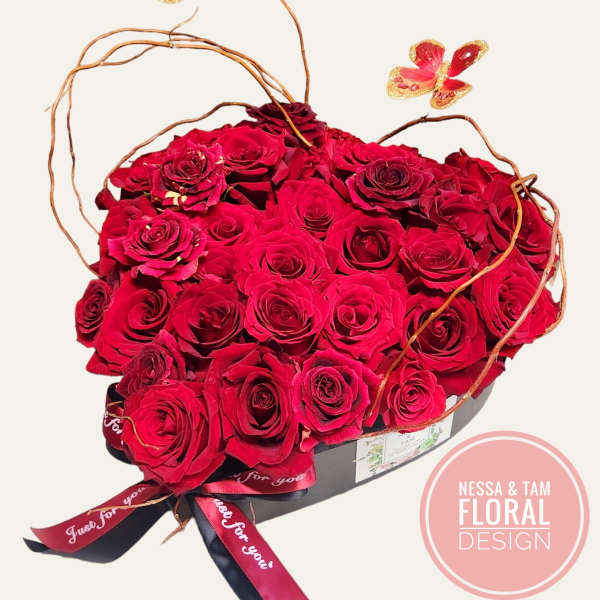 Heart-shaped box of red roses with butterfly picks
