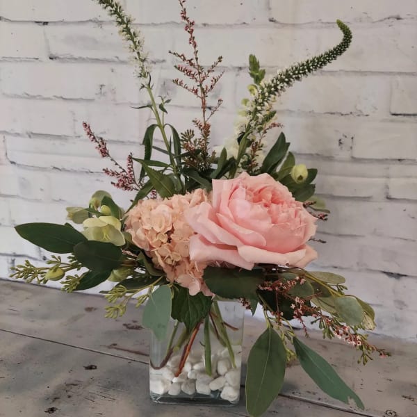 Pink rose and hydrangea arrangement in a clear glass vase
