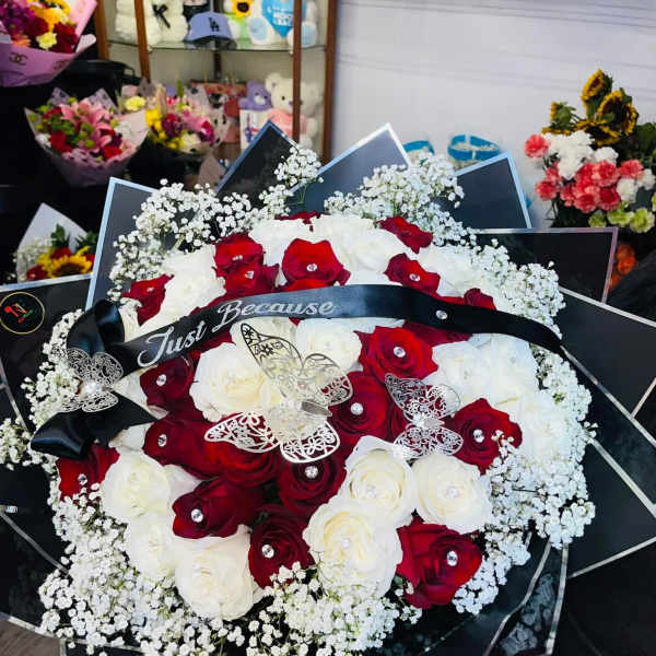 Red and white rose bouquet with baby's breath and a black ribbon