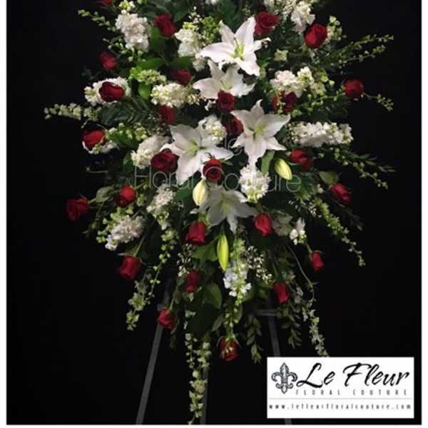 Standing floral spray with red roses and white lilies on a black background