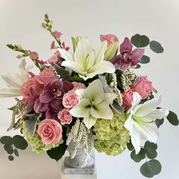 Pink roses and white lilies arranged in a gray vase