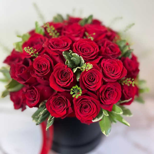 Bouquet of red roses in a black box with a red ribbon
