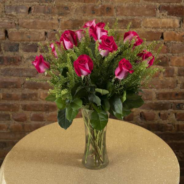 Pink roses in a clear glass vase on a table