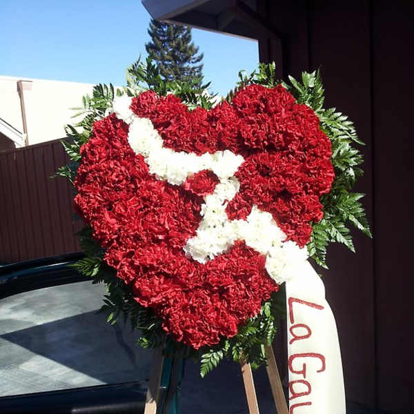 Heart-shaped red and white floral standing tribute with a ribbon