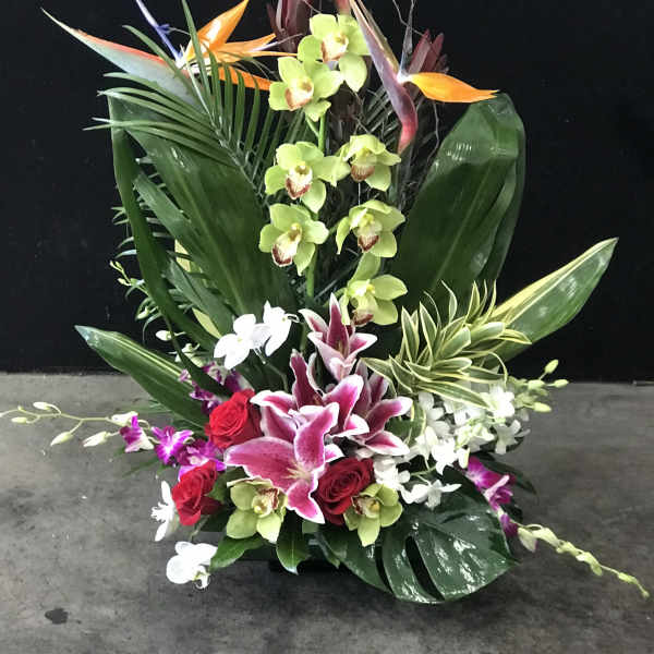 Tall tropical flower arrangement with orchids, roses, and bird of paradise