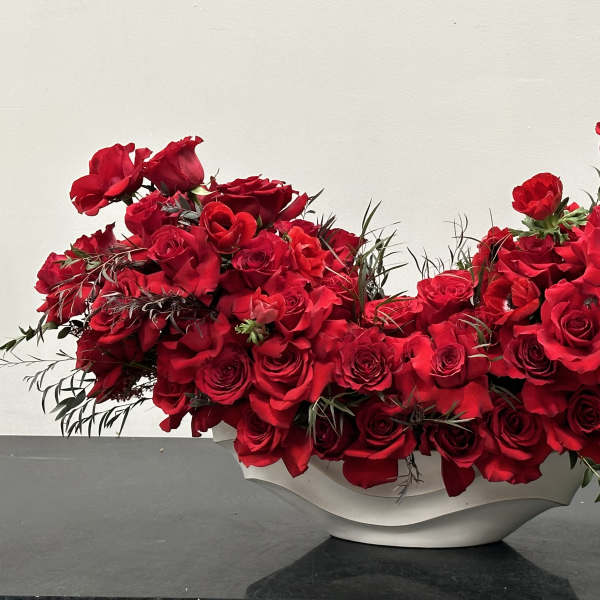 Red roses arranged in a white bowl vase