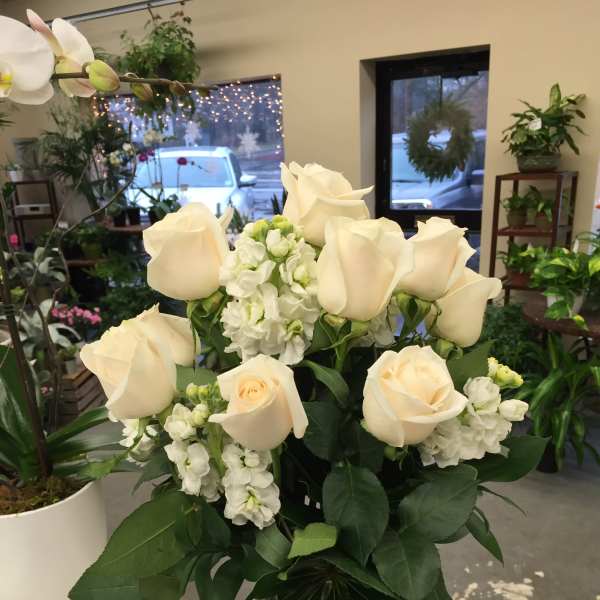 White roses and stock in a clear glass vase