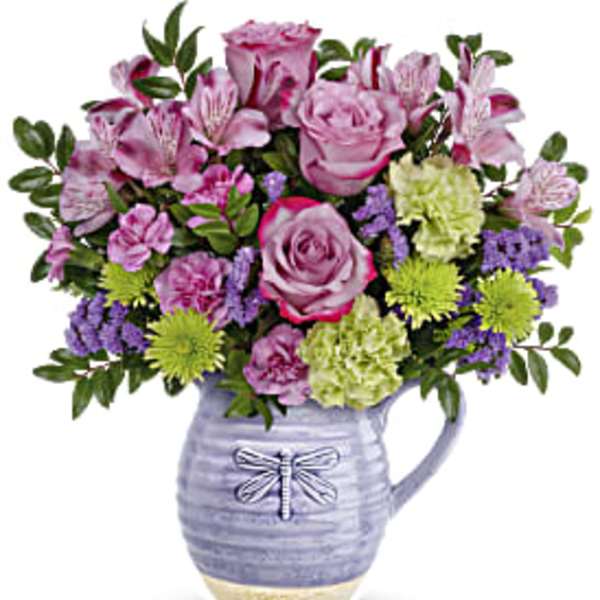 Pink and purple flower arrangement in a lavender ceramic pitcher