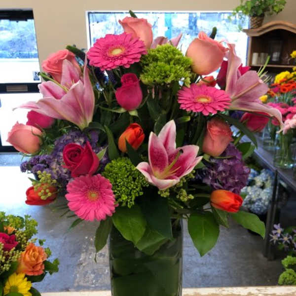 Pink and peach mixed bouquet in a tall glass vase
