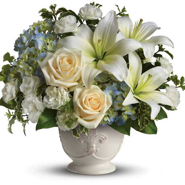 White lilies and cream roses in a decorative vase