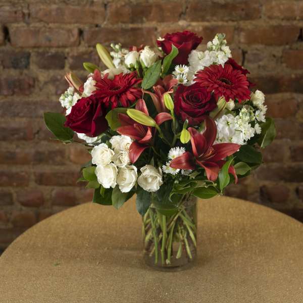 Red and white mixed flower bouquet in a glass vase