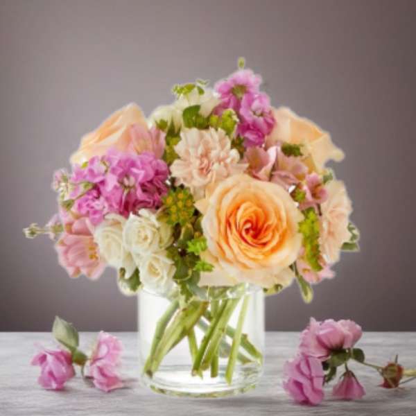 Peach and pink flower bouquet in a clear glass vase