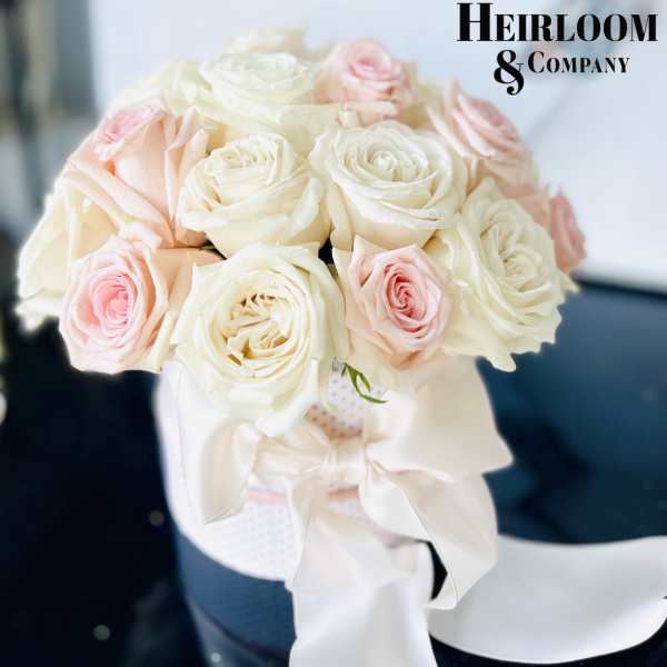 Bouquet of white and blush roses tied with a white ribbon