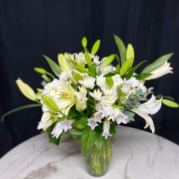 White lily bouquet in a clear glass vase