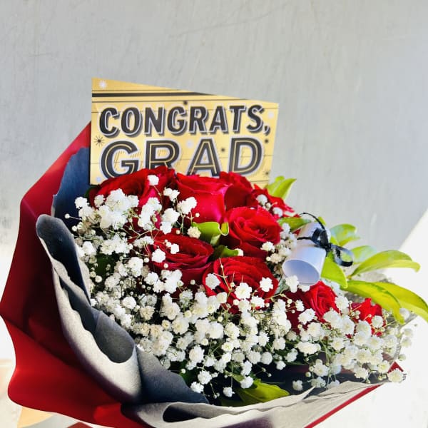 Bouquet of red roses with baby's breath and a congrats grad card