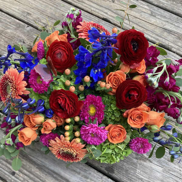 Colorful mixed bouquet with red, orange, blue, and pink flowers