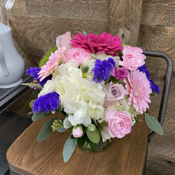 Pink and white mixed flower arrangement in a glass vase